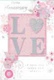 This anniversary card is depicted in a softly lit scene, its design blending tender sentiment with the quiet sophistication associated with Chelsea's elegant residences. The central feature is the word LOVE, each capital letter formed in soft, raised glitter that appears velvety rather than harshly sparkling. The O is transformed into a shimmering heart, filled with fine silver texture that seems almost metallic in the light. This central motif rests on a blush-pink panel, subtly framed and slightly lifted from the rest of the card to create a gentle sense of depth. Surrounding the word is a graceful arrangement of illustrated blooms, their petals in shades of blush and mauve with hints of creamy white. The flowers are drawn with a light touch, their outlines fine and flowing, giving them the appearance of watercolor blossoms drifting across the surface. Slender vines, swirling tendrils, and tiny leaves weave through the design, while small butterflies and subtle petal details add a feeling of movement, as if a soft breeze had passed along Chelsea Embankment and stirred a bouquet. The background is a soft pastel pink that provides a calm, warm base for the central decoration. Elegant script phrases-On Our Anniversary above, and I love you today and always inside-are written in a refined, flowing hand, their dark ink contrasting gently against the pale tones. The card stock appears smooth and of good weight, with a semi-matte finish allowing the glitter and silver elements to stand out without glare. The overall impression is one of cherished intimacy and enduring romance, the kind of card a couple might exchange after a relaxed anniversary stroll through Chelsea Physic Garden, keeping it later like a handwritten love note folded between shared memories.